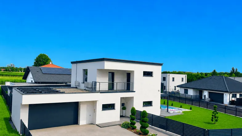 Modernes Einfamilienhaus mit Flachdach, integrierter Garage und gepflegter Außenanlage in sonniger Lage.