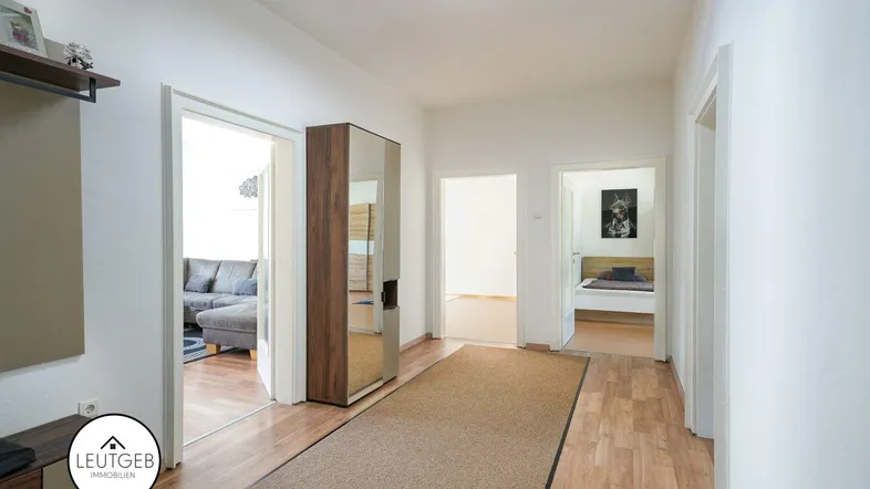 Heller Flur mit Holzfußboden und Zugang zu verschiedenen Zimmern der Wohnung.