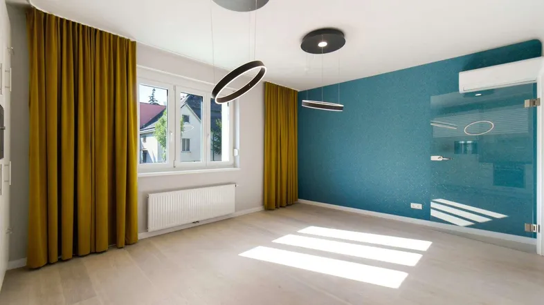Helles Wohnzimmer mit modernem Design, blauer Akzentwand und großen Fenstern.