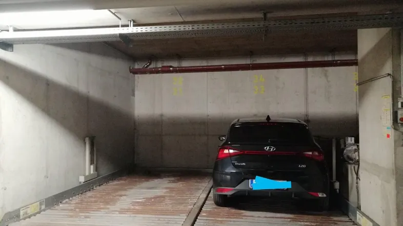 Ein Auto in einem automatischen Parksystem in einer Tiefgarage mit Betonwänden.