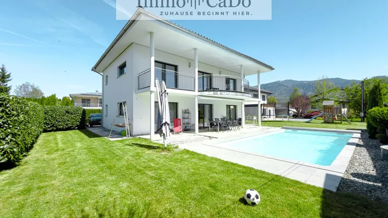Großzügiger Gartenbereich mit Rasenfläche, privatem Pool und Blick auf die umliegende Landschaft.