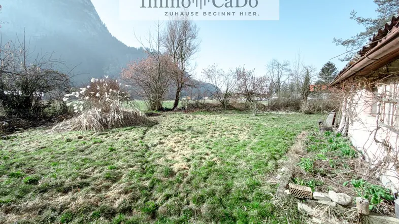 Großes Grundstück mit Grasfläche und Blick auf die umliegenden Berge, ideal für Naturliebhaber.