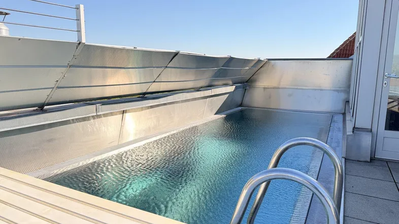 Dachterrasse mit modernem Pool und klarem Himmel, ideal zum Entspannen und Sonnenbaden.