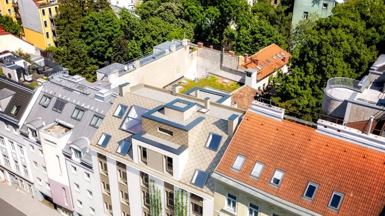 Luftaufnahme eines modernen Gebäudes mit Dachterrasse und weitem Blick über die Stadt Wien.