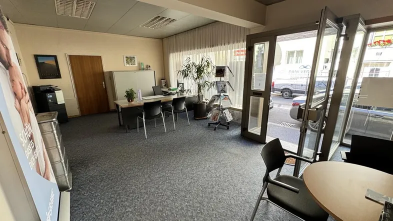 Großzügiger Empfangsbereich oder offenes Büro mit Teppichboden und viel Tageslicht durch die Eingangstür.