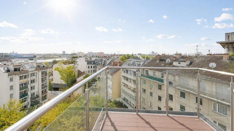 Große Dachterrasse mit Holzboden und Glasgeländer bietet einen weiten Blick über die Stadt.