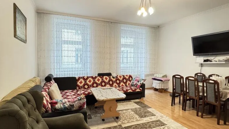 Geräumiger Wohn-Essbereich mit bequemen Sofas, Esstisch und Holzboden, ideal für geselliges Beisammensein.