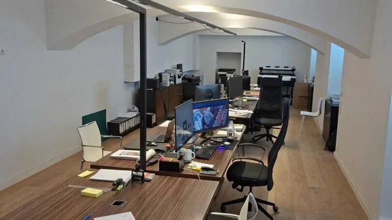 Geräumiges Büro mit mehreren Arbeitsplätzen, Holzboden und charakteristischen Gewölbedecken.