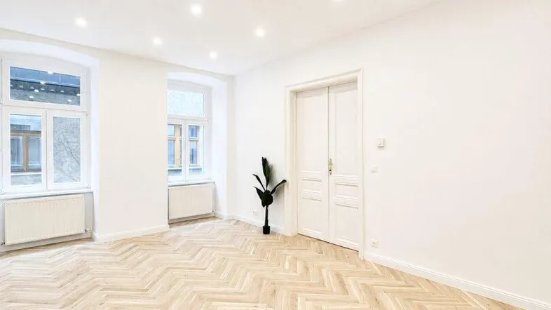 Helles, frisch renoviertes Zimmer mit Fischgrätparkett und hohen Decken, bereit zur individuellen Gestaltung.