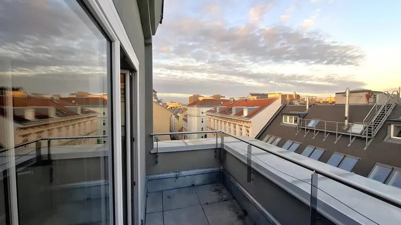 Geräumige Dachterrasse mit weitem Blick über die Stadt und umliegende Dächer.