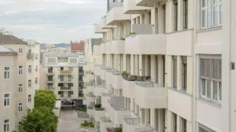 Moderne Wohnanlage mit vielen Balkonen und Blick auf die umliegende Stadt.