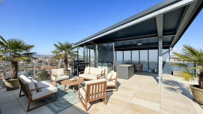 Große Dachterrasse mit Lounge-Möbeln, Grillbereich und Palmen unter blauem Himmel.