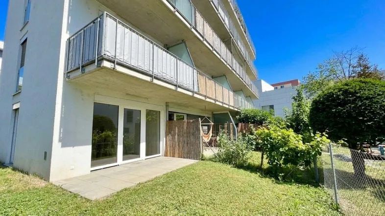 Erdgeschosswohnung mit kleiner Terrasse und direktem Zugang zum grünen Gartenbereich des Gebäudes.