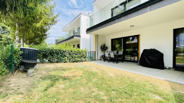 Moderne Wohnanlage mit großer Terrasse und privatem Gartenbereich, ideal für Entspannung im Freien.