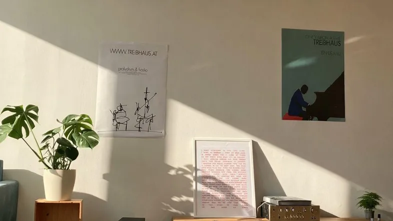 Helles Wohnzimmer mit Holzboden, moderner TV-Bank und viel natürlichem Licht durch das Fenster.