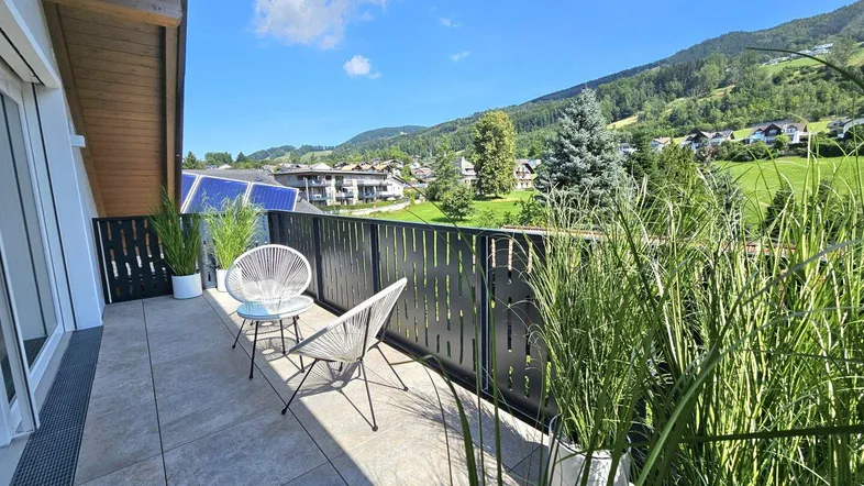 Attraktiver Balkon mit üppiger Bepflanzung und Panoramablick auf die umliegende Natur.