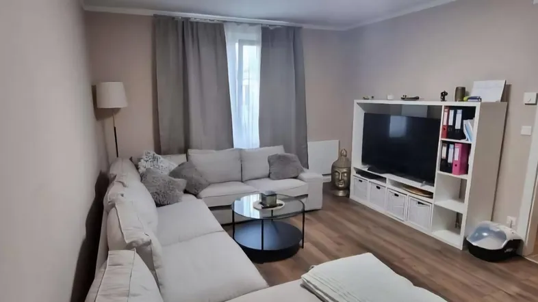 Gemütliches Wohnzimmer mit großem Ecksofa, Couchtisch und TV-Möbeln, ideal zum Entspannen.