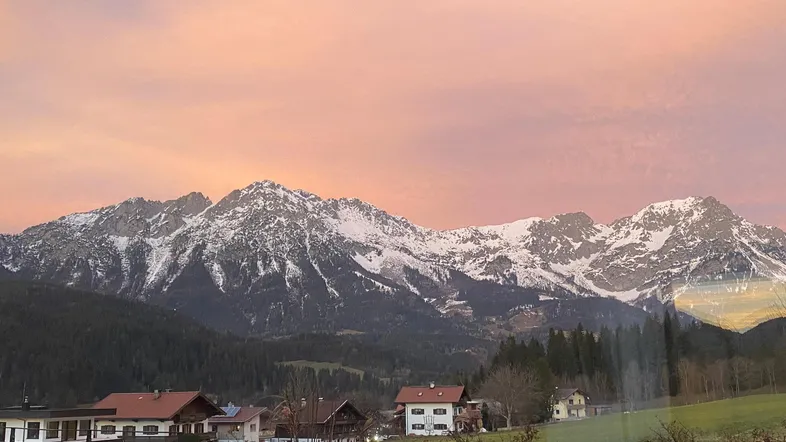 Atemberaubender Blick auf die schneebedeckten Berge bei Sonnenuntergang mit rosa Himmel.
