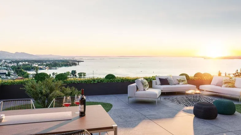 Geräumige Dachterrasse mit bequemen Loungemöbeln und atemberaubendem Seeblick bei Sonnenuntergang.