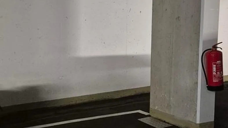 Tiefgaragenstellplatz M2 neben einer Betonsäule mit Feuerlöscher, typisch für eine moderne Tiefgarage.