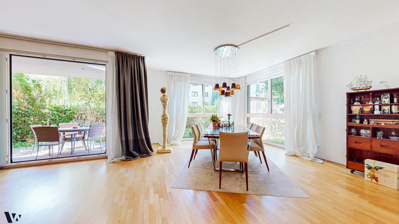 Eleganter Essbereich mit Holzboden, großem Esstisch und direktem Zugang zur Außenterrasse.