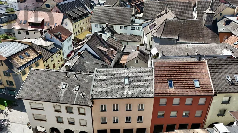 Luftaufnahme einer historischen Stadt mit vielen Dächern und Gebäuden, die eine dichte Bebauung zeigen.