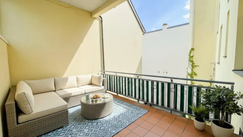 Gemütliche Terrasse mit bequemen Loungemöbeln und Blick auf den Innenhof.