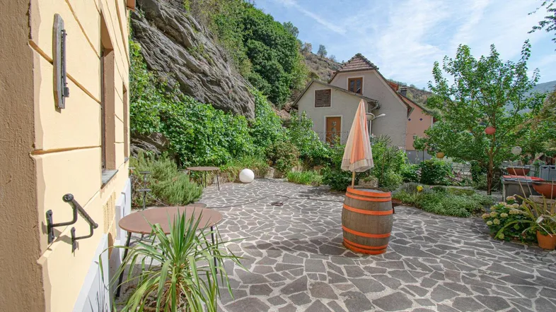 Gepflasterte Terrasse mit Sitzgelegenheiten und Blick auf die umliegende Felslandschaft und Natur.