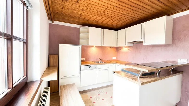 Helle Küche mit Holzdecke, weißen Schränken und einer Kochinsel mit Holzarbeitsplatte.