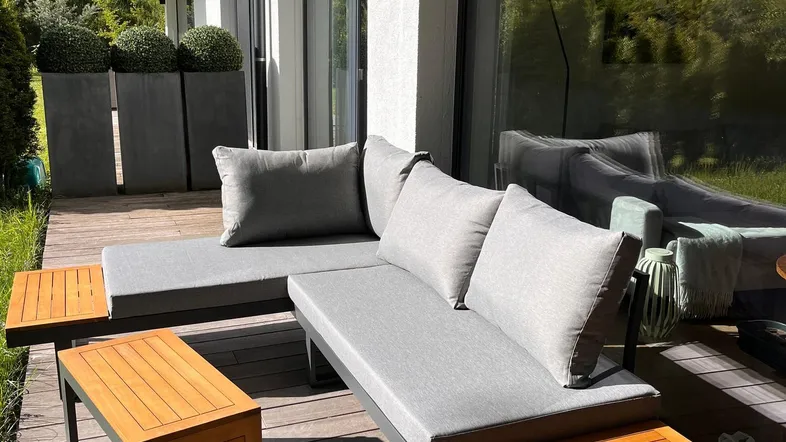 Moderne Terrasse mit bequemen Lounge-Möbeln auf Holzdeck und Blick ins Grüne.
