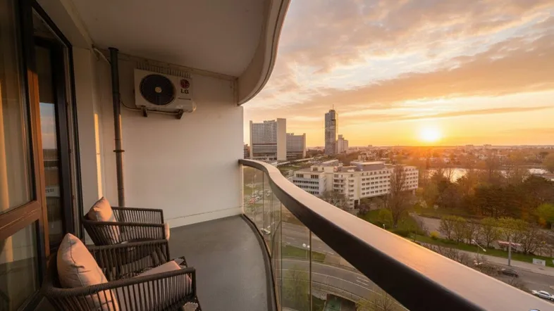 Balkon bei Sonnenuntergang mit Panoramablick auf die Stadt und den See.