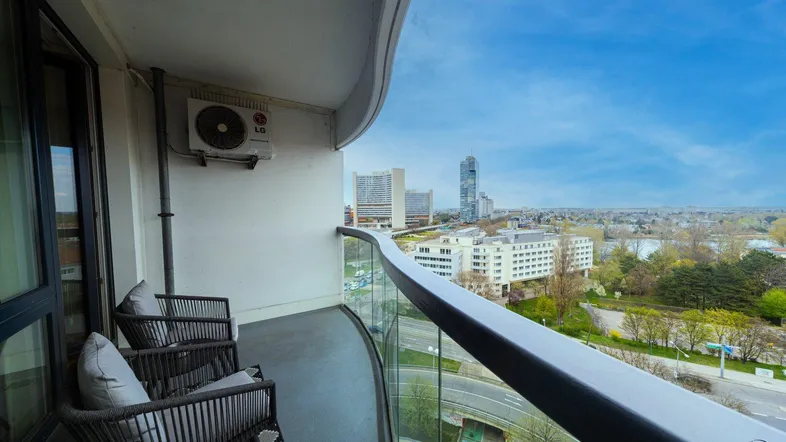 Geräumiger Balkon mit Glasbrüstung und weitem Blick über die Stadt und die Umgebung.