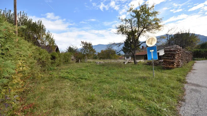 Weitläufiges Grundstück mit Grasfläche, Bäumen und Blick auf die umliegende Berglandschaft.