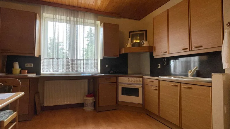 Küche im traditionellen Stil mit Holzschränken, Holzdecke und einem Fenster über der Spüle.