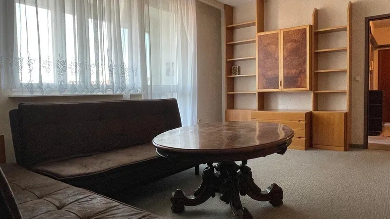 Wohnzimmer mit Teppichboden, bequemer Couch und klassischem Couchtisch, bietet viel Platz zum Entspannen.