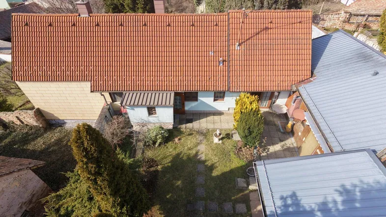 Luftaufnahme eines Hauses mit rotem Ziegeldach und einem gepflegten Gartenbereich.