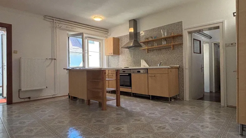 Geräumige Küche mit funktionalen Holzschränken, Kücheninsel und traditionellen Fliesen.