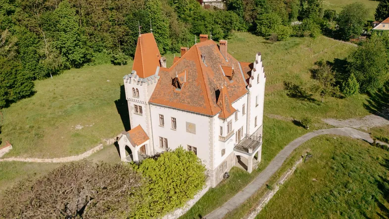 Luftaufnahme des historischen Anwesens mit weitläufigen Grünflächen und Wegen.