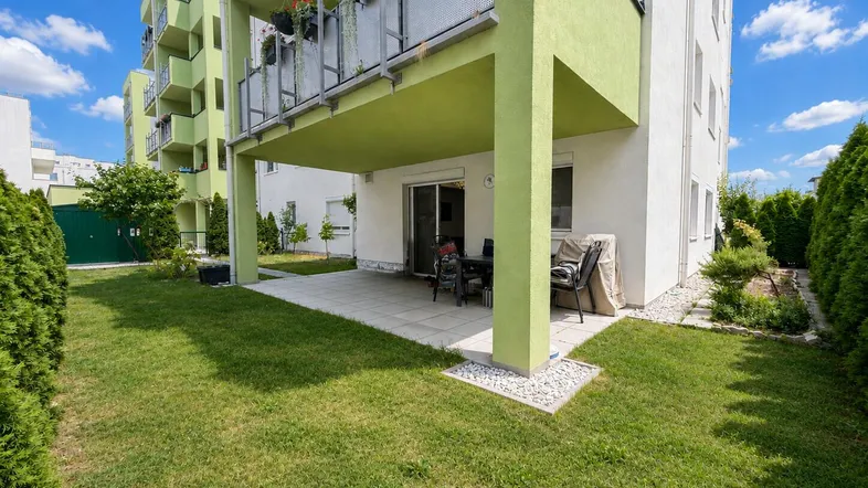Geräumige Terrasse mit Gartenmöbeln und direktem Zugang zum gepflegten Rasenbereich.