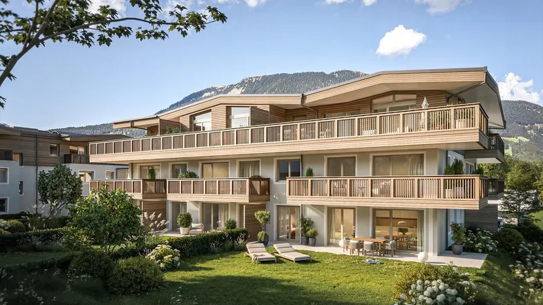 Moderne Wohnanlage mit Balkonen, Terrassen und Gartenbereich, umgeben von alpiner Landschaft.