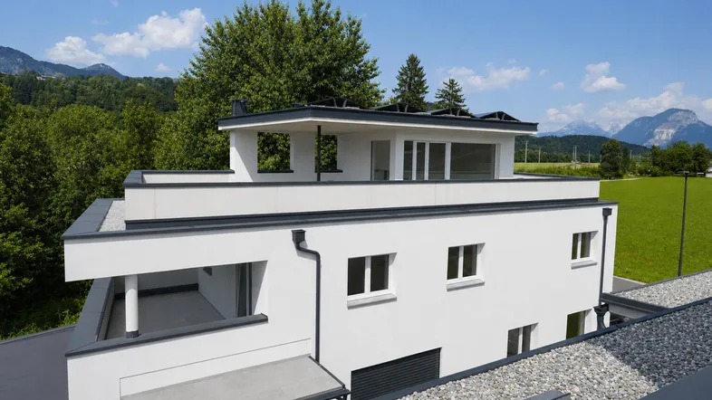 Modernes Gebäude mit Flachdach und weitem Blick auf die umliegende Berglandschaft.
