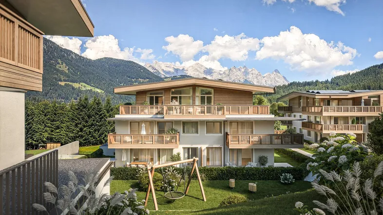 Moderne Wohnanlage in alpiner Umgebung mit Bergblick und Kinderspielplatz im Grünen.
