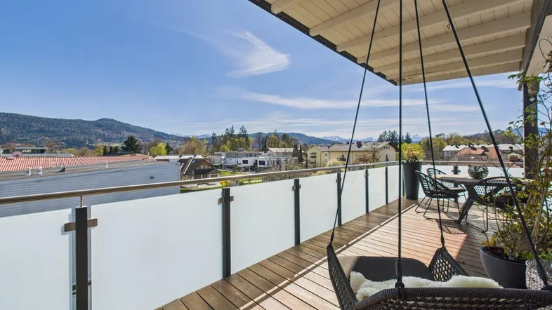 Geräumige Dachterrasse mit Holzboden, Hängesessel und weitem Blick auf die Berge und die Umgebung.