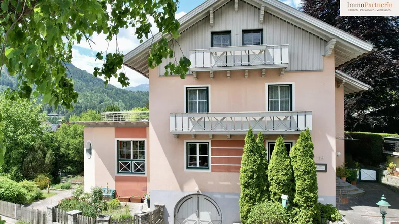 Charmantes Haus mit mehreren Balkonen und Blick auf die umliegende Berglandschaft.