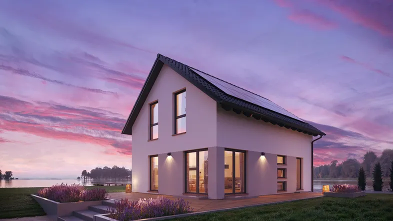 Modernes Einfamilienhaus am Seeufer bei Sonnenuntergang mit Photovoltaikanlage auf dem Dach.