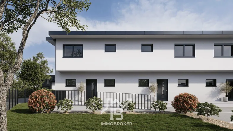 Moderne Reihenhausfassade mit barrierefreiem Zugang über eine Rampe und gepflegter Grünfläche.