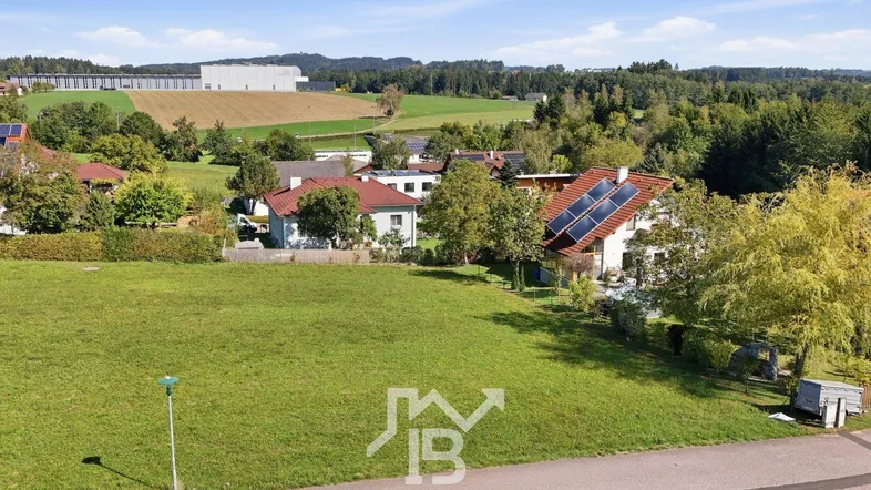 Weitläufiges grünes Grundstück mit Blick auf umliegende Häuser und ländliche Landschaft.