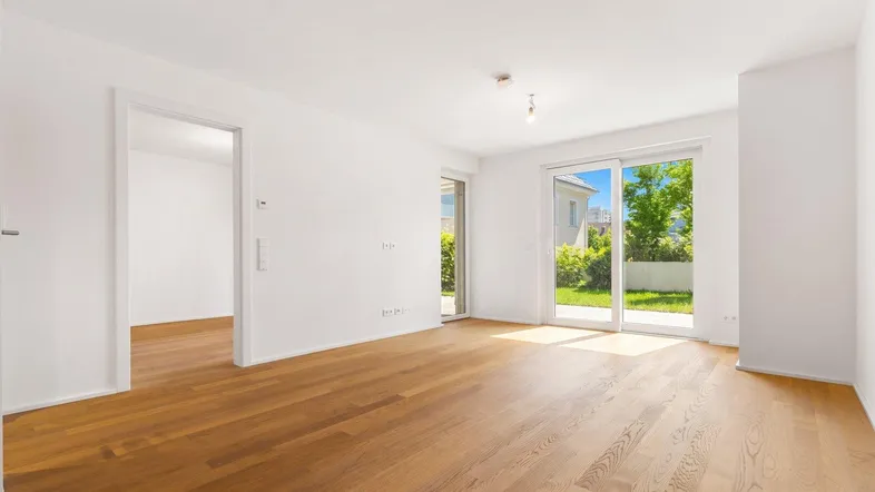 Heller Wohnraum mit Parkettboden und großen Schiebetüren zum Gartenbereich.