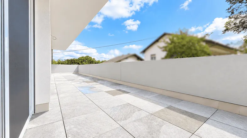 Große, geflieste Terrasse mit weitem Blick und viel Tageslicht, ideal zum Entspannen.