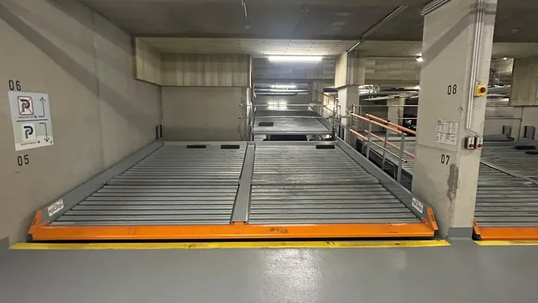 Tiefgarage mit modernen mechanischen Parksystemen für effiziente Raumnutzung und helle Beleuchtung.